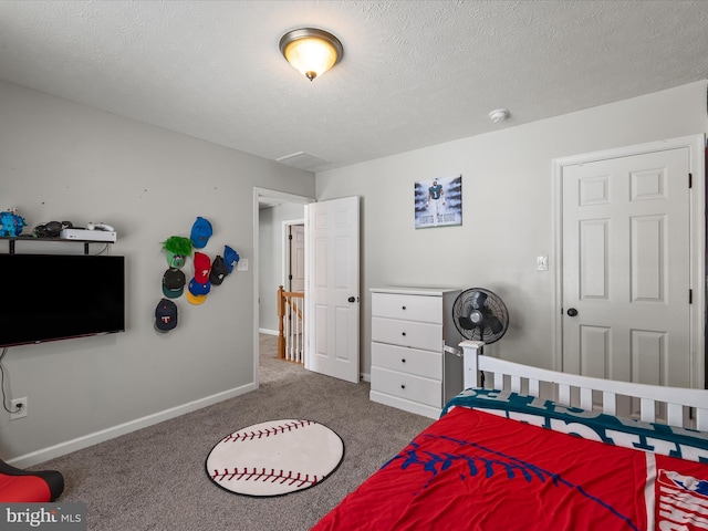 bedroom with carpet floors and a textured ceiling