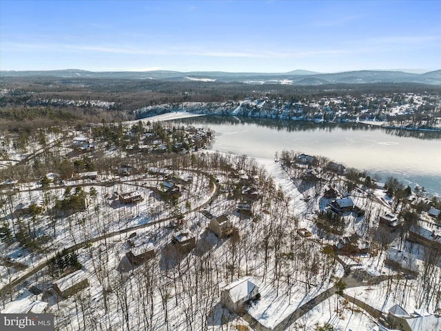 snowy aerial view featuring a water and mountain view