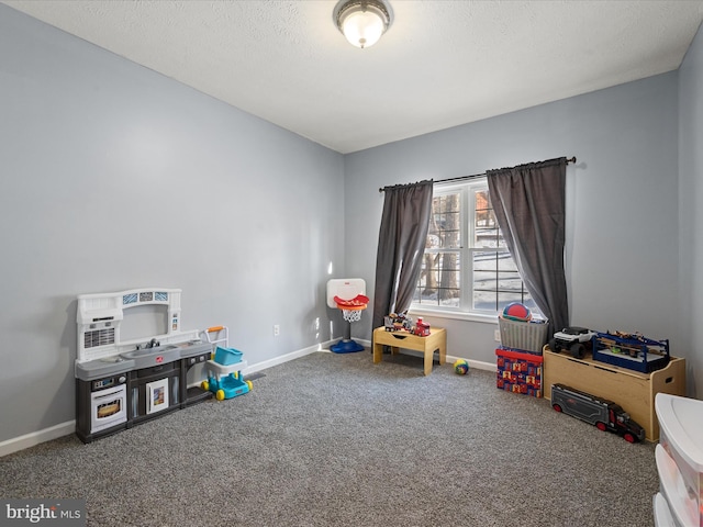 game room with a textured ceiling and carpet flooring