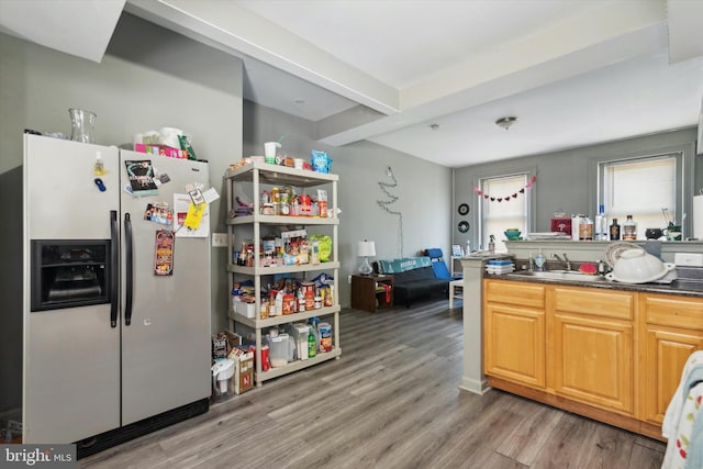 kitchen featuring beamed ceiling, hardwood / wood-style floors, stainless steel fridge, and sink