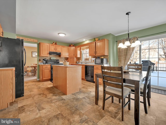 kitchen with a healthy amount of sunlight, decorative light fixtures, a kitchen island, and black appliances