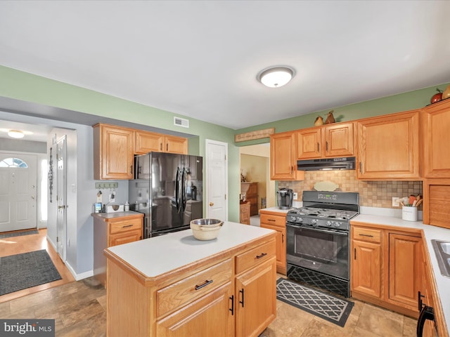 kitchen with a center island, backsplash, and black appliances