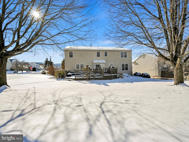 snow covered property with a wooden deck