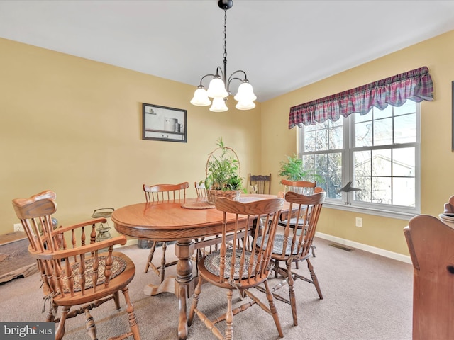 dining space featuring a notable chandelier and carpet flooring