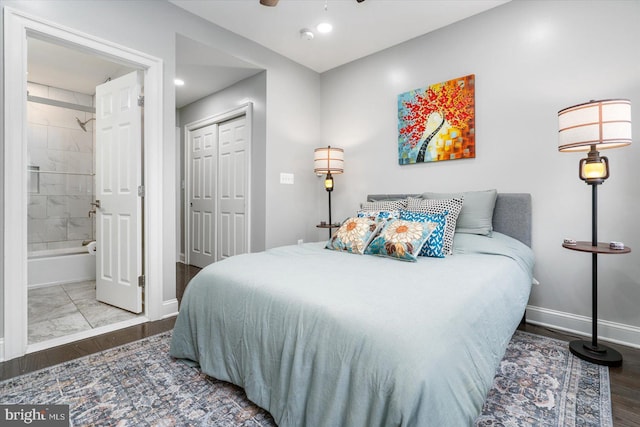 bedroom featuring a closet, ensuite bathroom, wood-type flooring, and ceiling fan