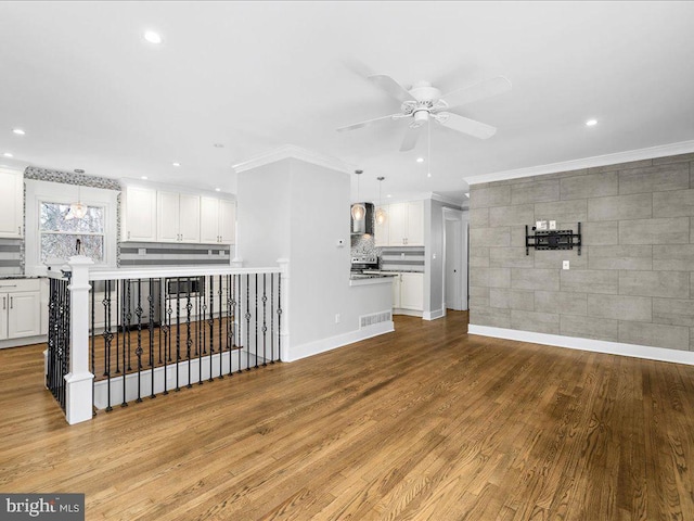 unfurnished living room featuring ornamental molding, ceiling fan, and light hardwood / wood-style floors