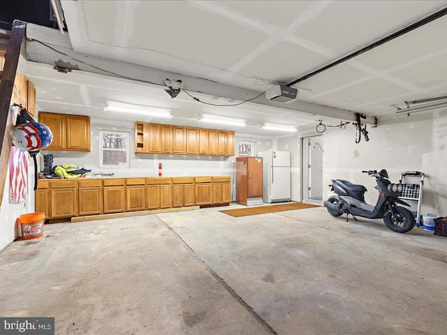 garage with a garage door opener and white fridge