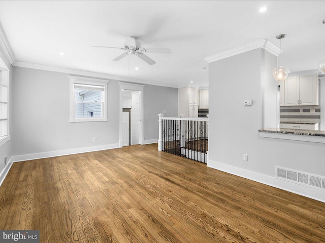 unfurnished living room featuring ceiling fan, ornamental molding, and hardwood / wood-style floors