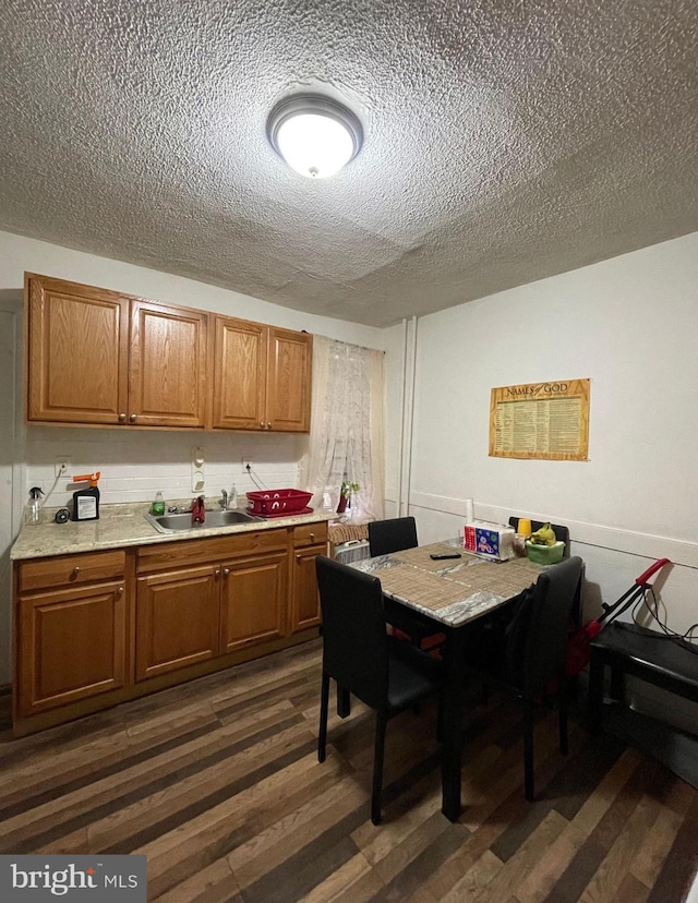 dining room featuring a textured ceiling, dark hardwood / wood-style flooring, and sink