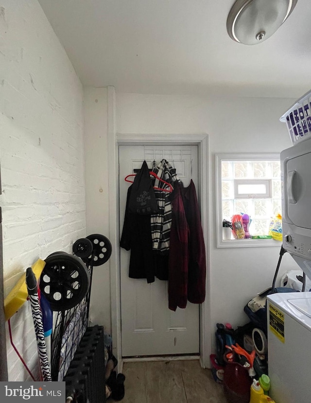 clothes washing area with stacked washer and dryer