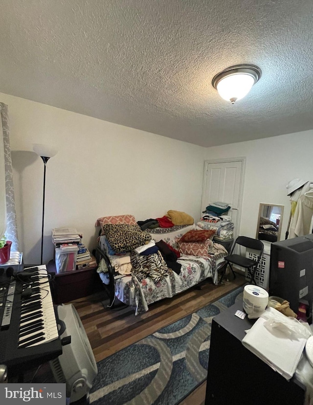 bedroom featuring dark hardwood / wood-style flooring and a textured ceiling