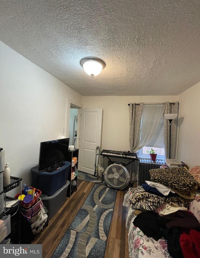 bedroom with a textured ceiling and dark wood-type flooring