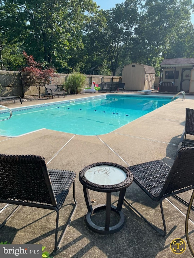 view of pool featuring a diving board and a storage unit