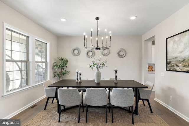 dining space featuring hardwood / wood-style floors and a notable chandelier