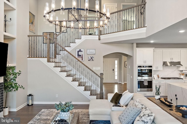 living room featuring dark wood-type flooring and a high ceiling