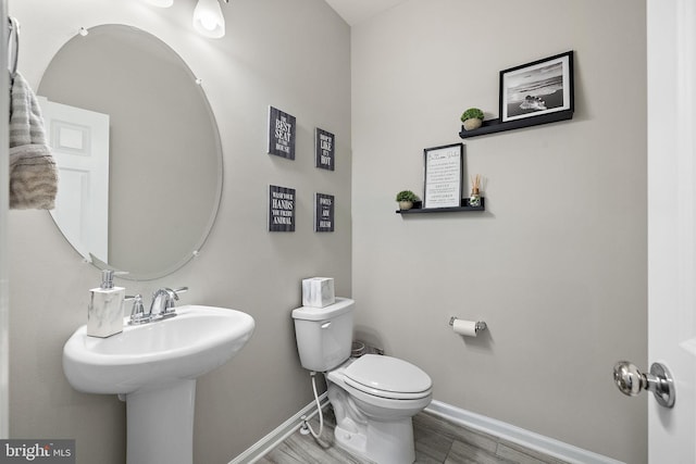 bathroom featuring sink, hardwood / wood-style flooring, and toilet