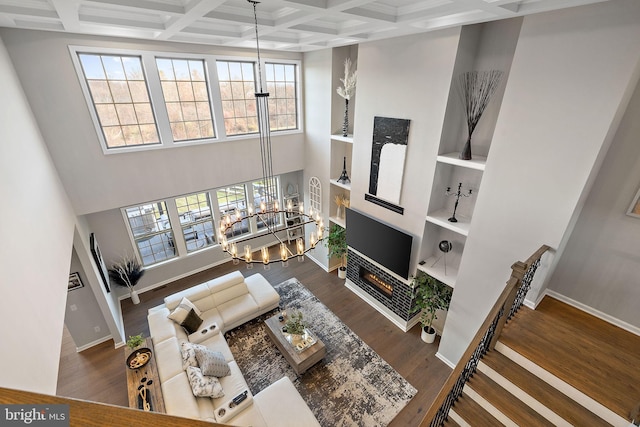 living room featuring coffered ceiling, plenty of natural light, and beamed ceiling