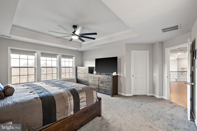 carpeted bedroom featuring ceiling fan and a raised ceiling