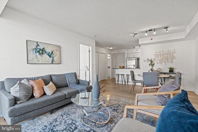 living room with light hardwood / wood-style floors and a textured ceiling