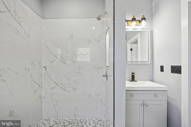 bathroom featuring tiled shower and vanity