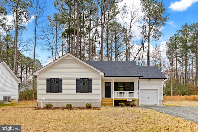 ranch-style house featuring a garage, central AC unit, and a porch