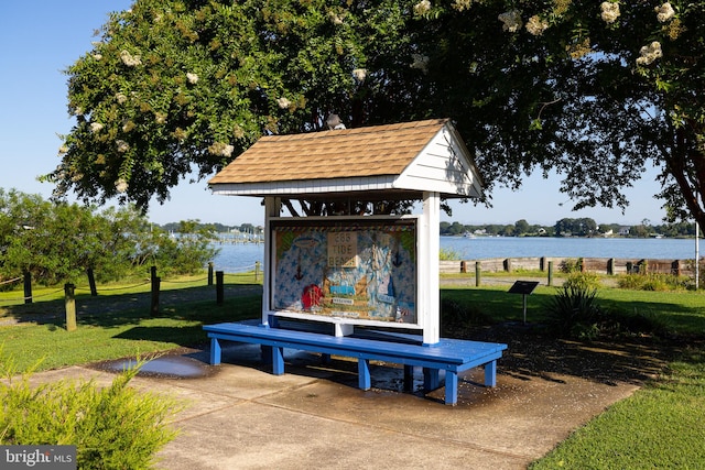 view of community featuring a water view and a yard