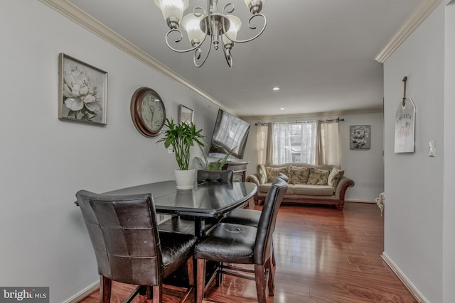 dining space with crown molding, dark hardwood / wood-style flooring, and an inviting chandelier