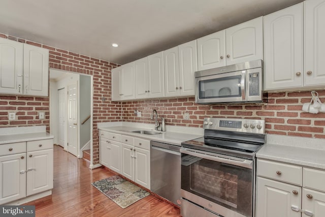 kitchen with sink, white cabinets, and appliances with stainless steel finishes