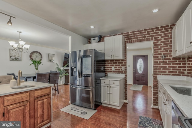 kitchen featuring stainless steel appliances, pendant lighting, white cabinetry, and sink