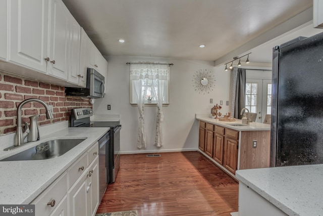 kitchen featuring light stone countertops, sink, white cabinetry, and stainless steel appliances