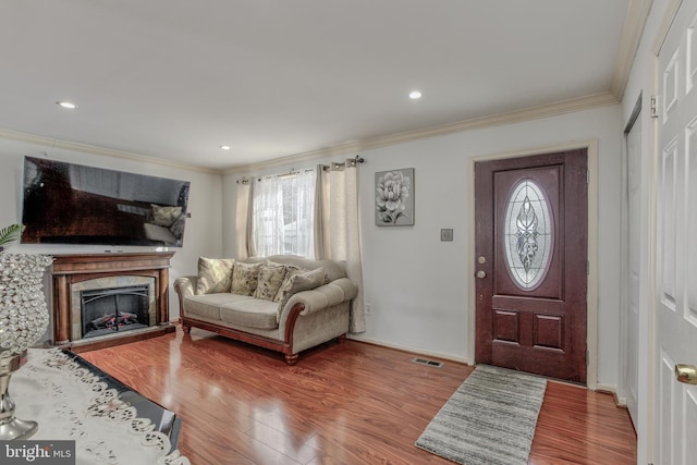 foyer with hardwood / wood-style flooring and crown molding