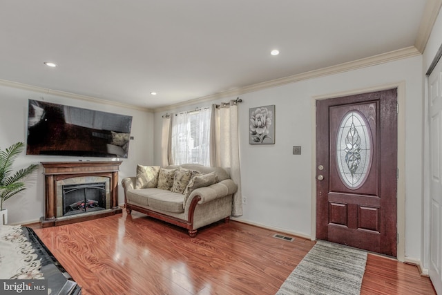 entrance foyer with ornamental molding and hardwood / wood-style flooring