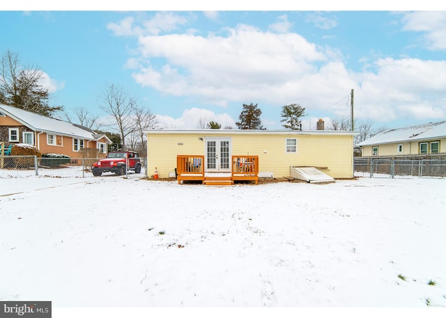 snow covered property featuring french doors and a wooden deck