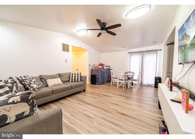 living room with light wood-type flooring, vaulted ceiling, and ceiling fan