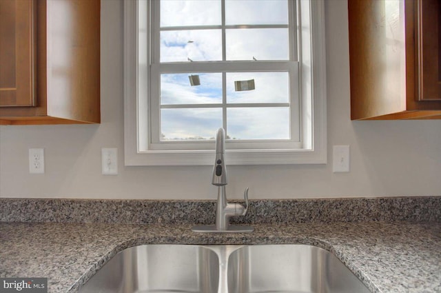 room details featuring light stone countertops and sink