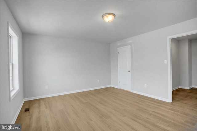 unfurnished room featuring light wood-type flooring and a healthy amount of sunlight