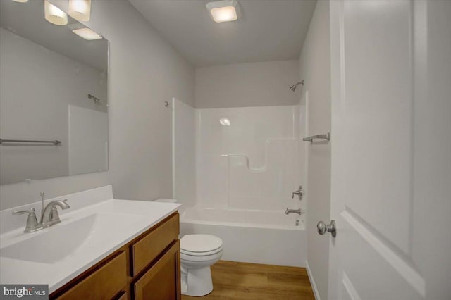 full bathroom featuring toilet, wood-type flooring, vanity, and bathtub / shower combination