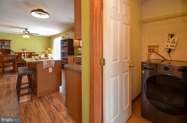 washroom with ceiling fan, washer / dryer, and light wood-type flooring