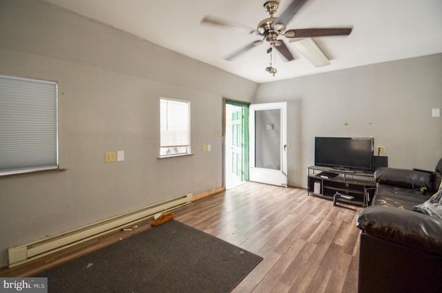 living room with ceiling fan, wood-type flooring, a baseboard heating unit, and lofted ceiling