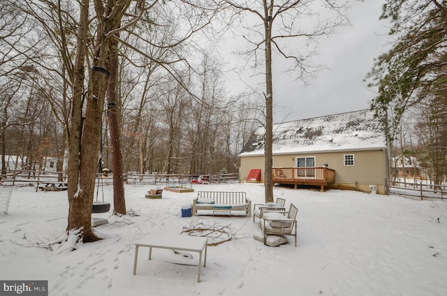 yard layered in snow with a deck