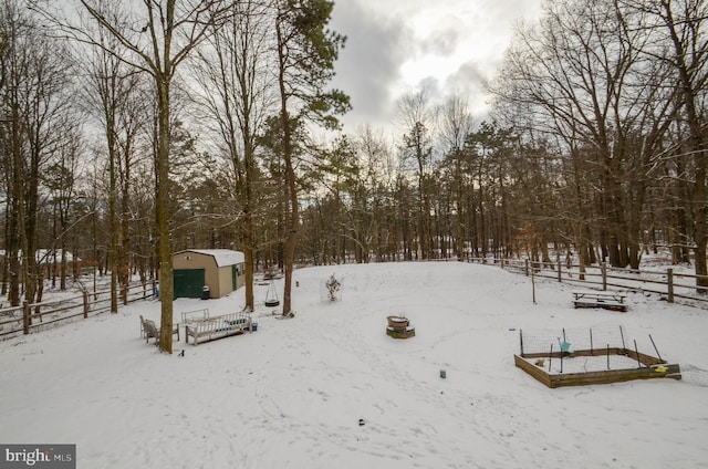 yard covered in snow featuring a storage unit