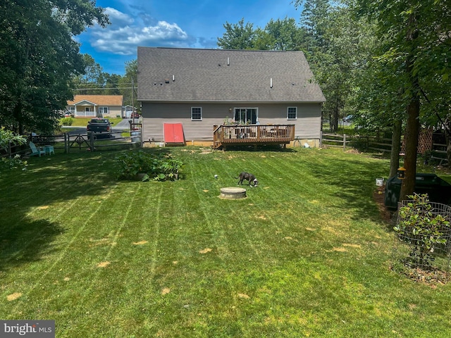 back of property featuring a lawn and a wooden deck