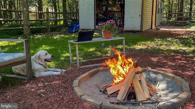 view of yard with a fire pit and an outdoor structure