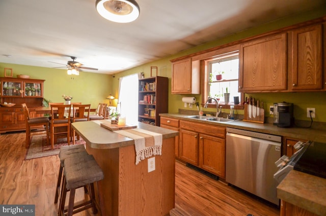 kitchen featuring hardwood / wood-style floors, plenty of natural light, dishwasher, a kitchen island, and sink