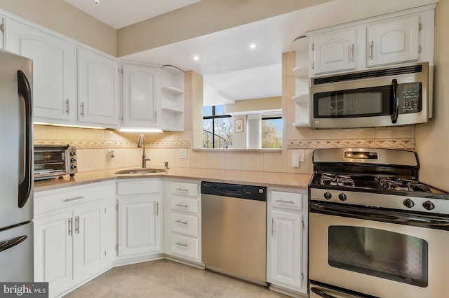 kitchen featuring sink, white cabinetry, appliances with stainless steel finishes, and tasteful backsplash