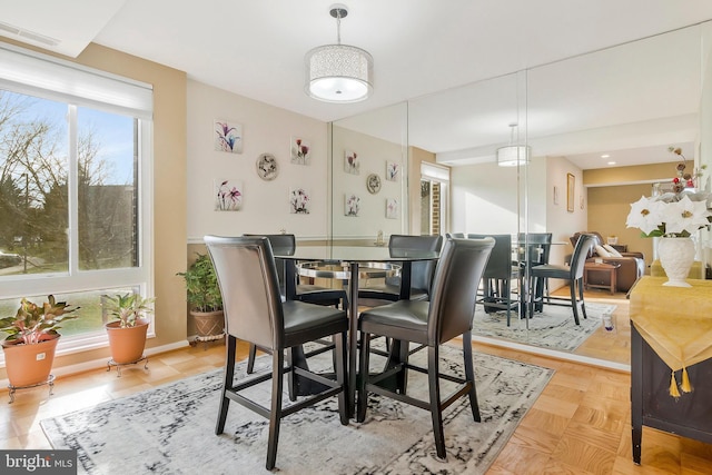 dining area featuring light parquet flooring and a healthy amount of sunlight