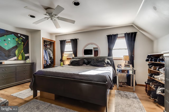 bedroom featuring multiple windows, a closet, vaulted ceiling, ceiling fan, and light hardwood / wood-style flooring