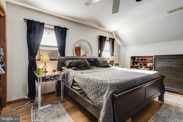 bedroom featuring hardwood / wood-style flooring, multiple windows, lofted ceiling, and ceiling fan