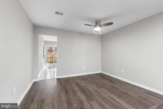 empty room featuring ceiling fan and dark hardwood / wood-style flooring