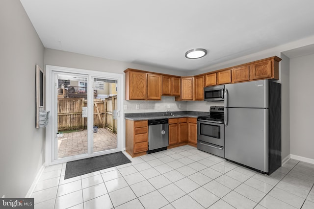 kitchen with sink, light tile patterned flooring, and appliances with stainless steel finishes